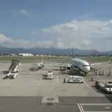 Samolot Ryanair na lotnisku Orio al Serio, pasażerowie wsiadają. W tle góry i chmury.