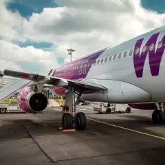 Samolot Wizz Air z fioletowym logo na tle chmur, gotowy do lotu z BVA Paris.