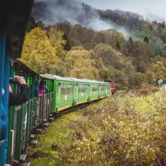 Zielony pociąg turystyczny w jesiennych Bieszczadach, podróż z Krakowa przez malownicze krajobrazy.