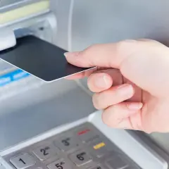 Wkładanie karty do bankomatu. Planując podróż, warto sprawdzić, czy w Norwegii można płacić euro.
