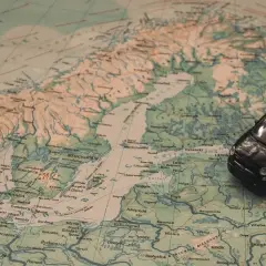 Czarny samochodzik na mapie Europy, wskazujący trasę z Warszawy na Mikołajki.
