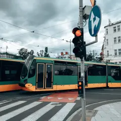 Zielony tramwaj w Poznaniu czeka na zielone światło. Gdzie kupić bilet na tramwaj poznań?