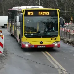 Autobus MPK linii 612 z napisem "KRZYKI" jedzie po drodze z robotami drogowymi. Jak dojechać na Bielany Wrocławskie MPK? Ten autobus może być odpowiedzią.