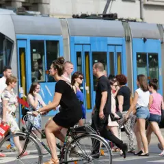 Ludzie przechodzą przez pasy, obok tramwaju z napisem "79 POŚWIETNE". To typowy widok wrocławskiego kod boczny pojazdu.