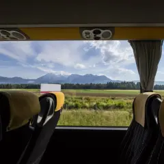 Widok z okna autobusu ze Słowenii na góry i pola.