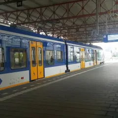 Niebiesko-biały pociąg na stacji, gotowy do podróży z Eindhoven do Amsterdamu.