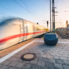 Pędzący pociąg z czerwonym pasem na tle zachodzącego słońca, jakby jechał z Castellon do Walencji.