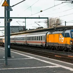 Pociąg z żółtą lokomotywą na stacji, gotowy do podróży do Niemiec.