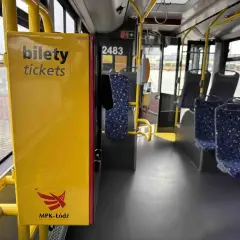 Żółty automat z napisem "bilety" i logo MPK-Łódź wewnątrz autobusu.