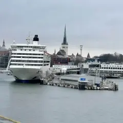 Prom Tallin Helsinki cena: duży prom pasażerski przycumowany w porcie, w tle zabytkowe budynki Tallina.