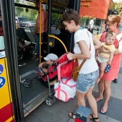Kobiety z dziećmi wsiadają do autobusu.
