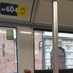 Numer boczny pojazdu kraków RP 604. Widok z okna tramwaju na zabytkową kamienicę.
