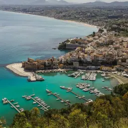 Widok na port w Trapani, z łodziami i miastem w tle. Idealne miejsce na podróż, jeśli planujesz lotnisko Marsala.