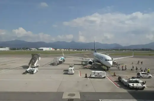 Samolot Ryanair na lotnisku Orio al Serio, pasażerowie wsiadają. W tle góry i chmury.