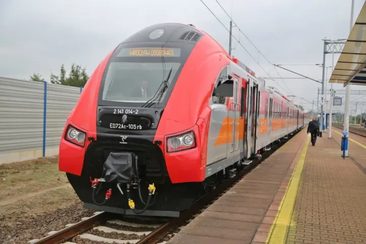 Czerwony pociąg ED72Ac-105rb z napisem "WROCŁAW OSOBOWICE" na peronie. Może to być początek podróży z Wrocławia do Międzyzdrojów.