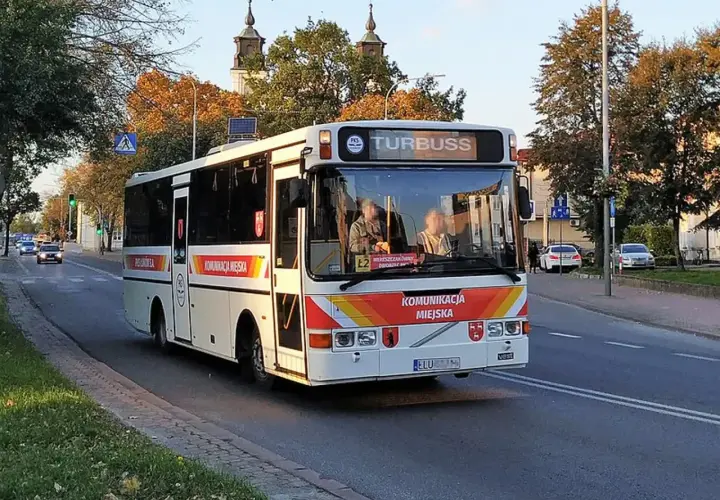 Autobus komunikacji miejskiej "Turbuss" na trasie Łuków-Lublin, z widocznymi herbami miasta i pasażerami.
