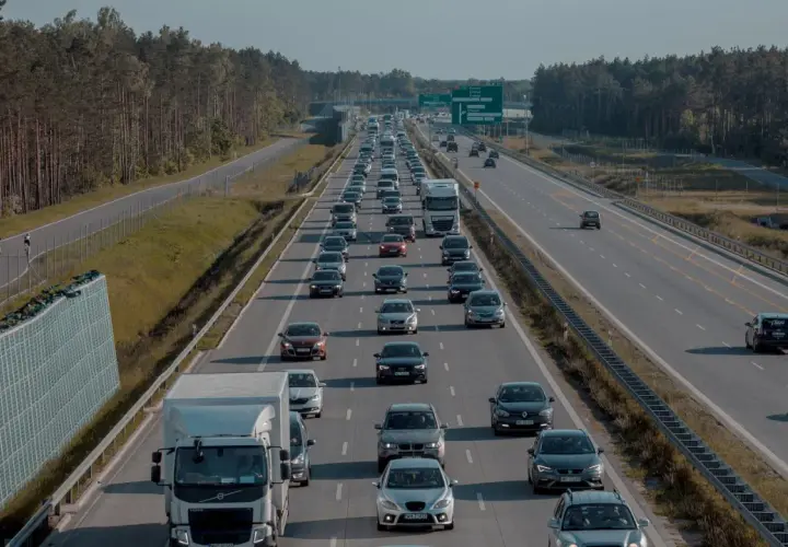 Korek na s2 trasa. Długi sznur samochodów i ciężarówek w drodze do celu, otoczony lasem.