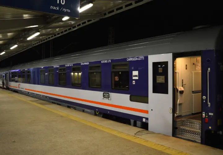 Pociąg kraków - kołobrzeg sypialny na peronie. Wagon z napisem "CARROZZA-LETTI" i ikoną łóżka zaprasza do podróży.