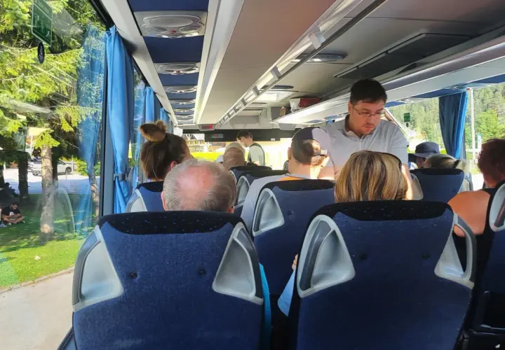 Pasażerowie w wygodnym autokarze do Londynu podziwiają zielone krajobrazy za oknem.