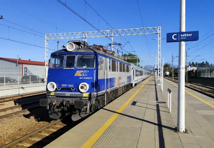 Niebiesko-szara lokomotywa PKP Intercity EP07-1022 na torach. Wyobraź sobie podróż poznań - zakopane pkp bezpośrednio tym pociągiem.