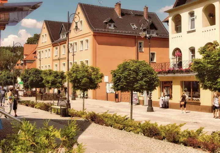 Spacerkiem po urokliwym deptaku w Świeradowie-Zdroju, gdzie kamienice i zielone drzewka tworzą atmosferę jak z Jeleniej Góry.