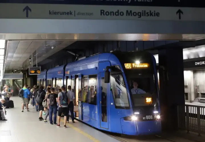 Tram 50 z Dworca Głównego w Krakowie do Prokocimia. Ludzie czekają na peronie.