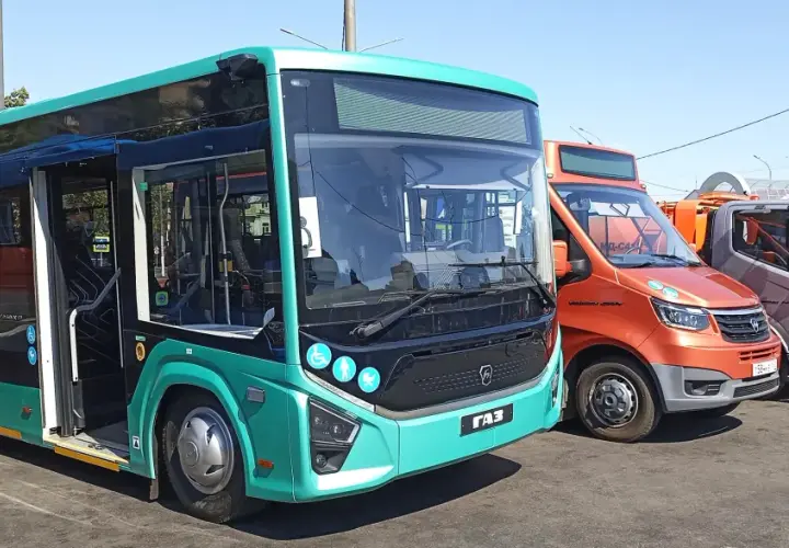 Nowe autobusy i samochody dostawcze stoją obok siebie. Jeden z autobusów, w kolorze turkusowym, ma otwarte drzwi, gotowy do podróży z Augustowa do Łodzi.