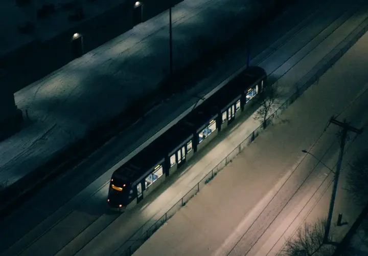 Nocny tramwaj w śnieżnej Warszawie, jak jeden z nielicznych autobusów nocnych, przemierza puste ulice.