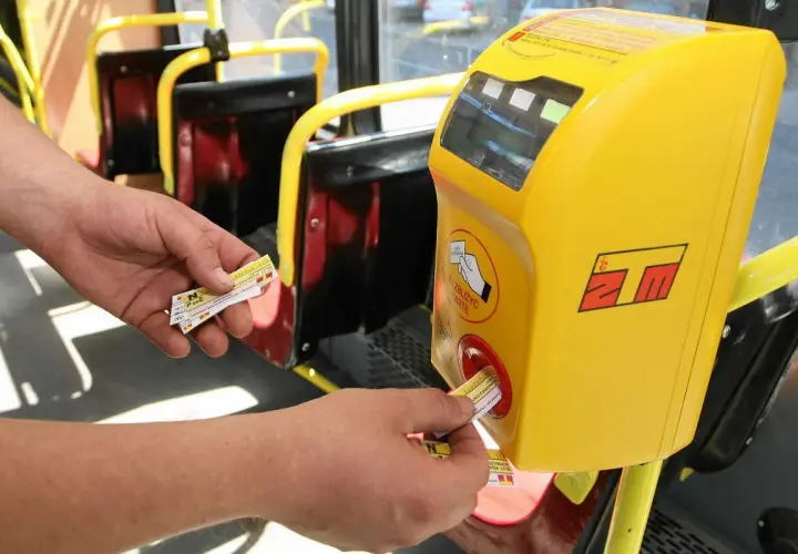 Ręka zbliża bilet do kasownika w autobusie. To prosty sposób, jak dojechać warszawa ztm.