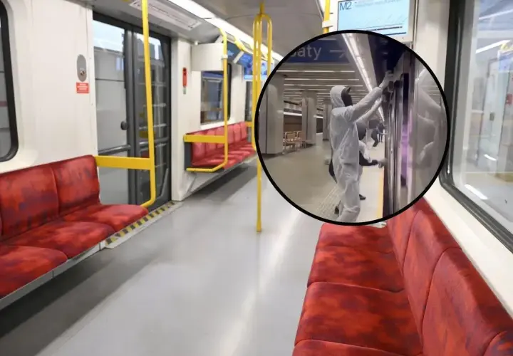 Wnętrze pustego wagonu metra na trasie M2. W okręgu pracownik w kombinezonie dezynfekuje drzwi.