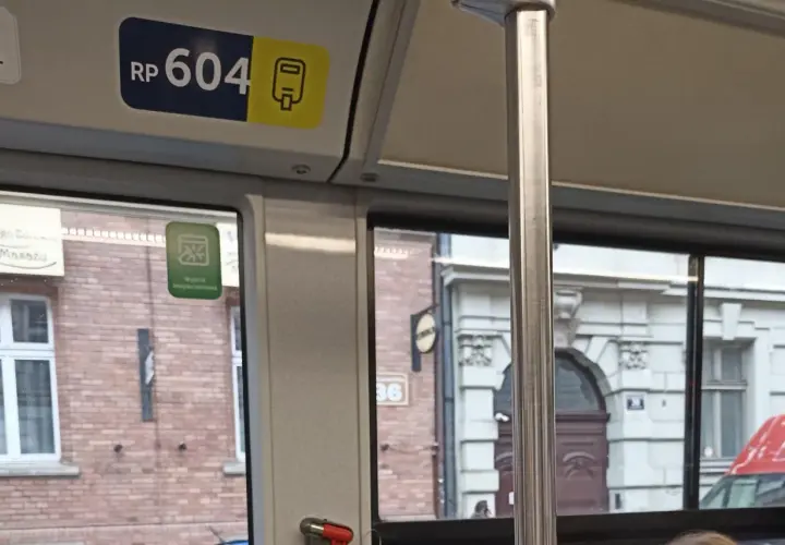 Numer boczny pojazdu kraków RP 604. Widok z okna tramwaju na zabytkową kamienicę.