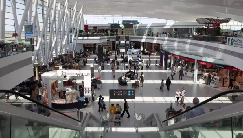 Tętniący życiem terminal lotniska w Budapeszcie, z ludźmi poruszającymi się po sklepach i kawiarniach, gotowi na transport z lotniska.
