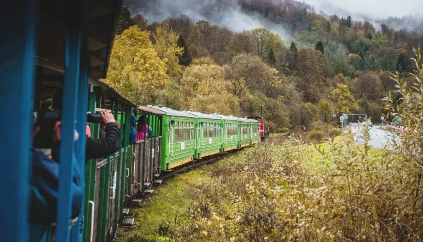 Zielony pociąg turystyczny w jesiennych Bieszczadach, podróż z Krakowa przez malownicze krajobrazy.