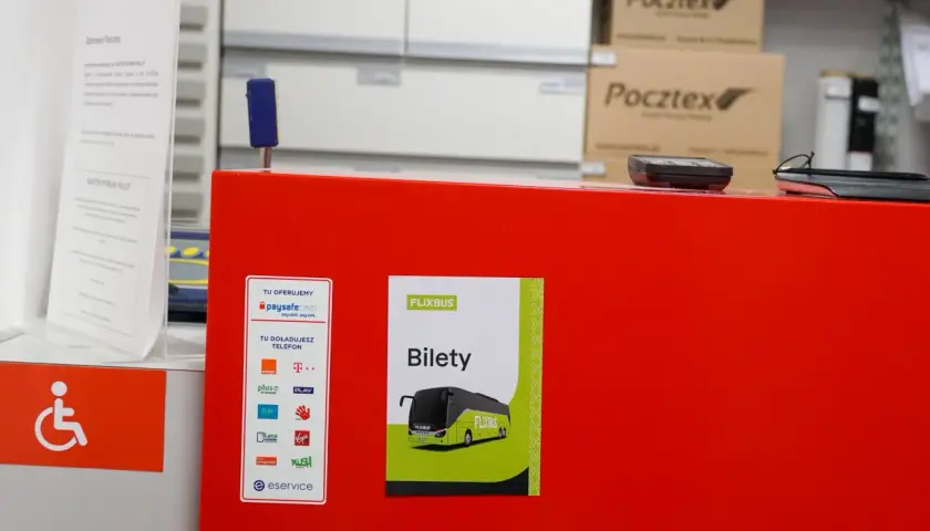 Na czerwonym blacie znajduje się plakat z napisem "Bilety Flixbus". Tutaj możesz kupić bilet na Flixbus.