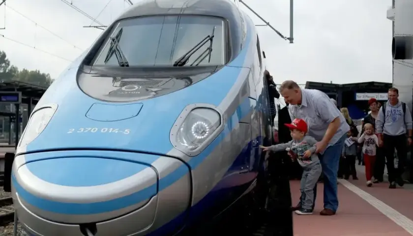 Rodzina podziwia nowoczesny pociąg Pendolino. Sprawdzają pociąg warszawa - gdańsk cena, by zaplanować podróż.