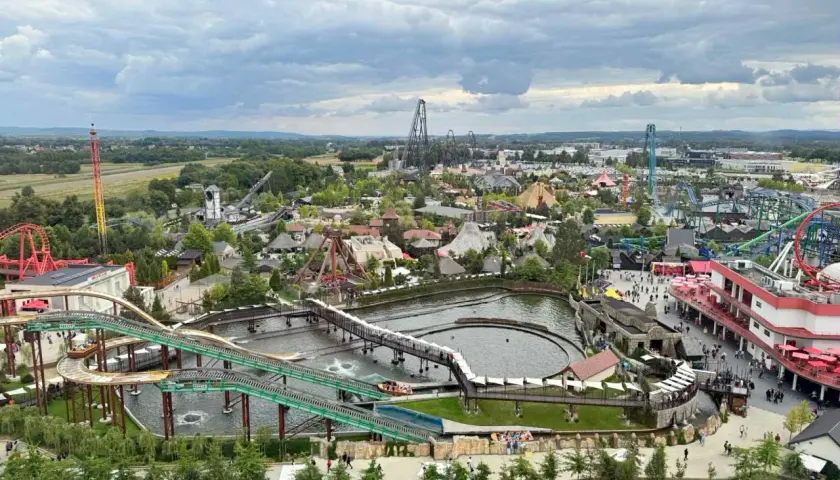 Widok na park rozrywki Energylandia w pobliżu Krakowa, z licznymi kolejkami górskimi, wodnymi atrakcjami i budynkami.