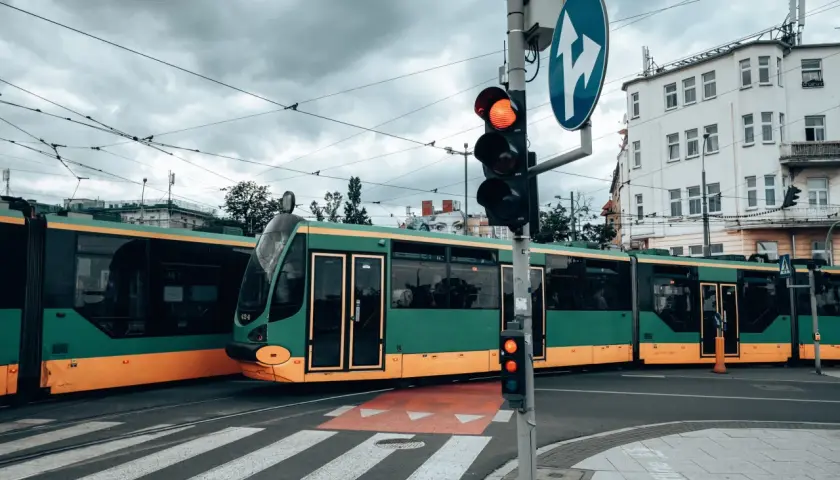 Zielony tramwaj w Poznaniu czeka na zielone światło. Gdzie kupić bilet na tramwaj poznań?