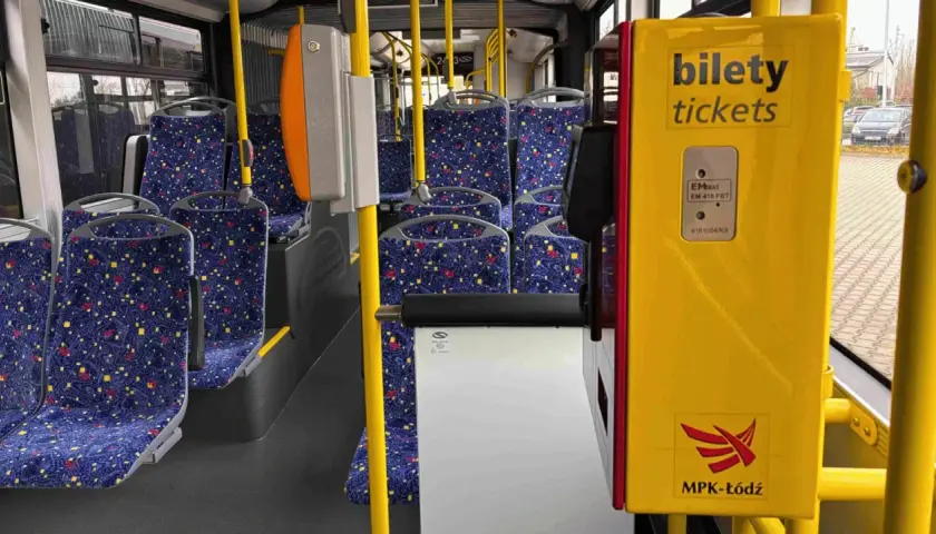 Wnętrze autobusu MPK-Łódź. Żółty automat biletowy z napisem "bilety tickets" obok siedzeń. Sprawdź bus łódź - uniejów cennik.