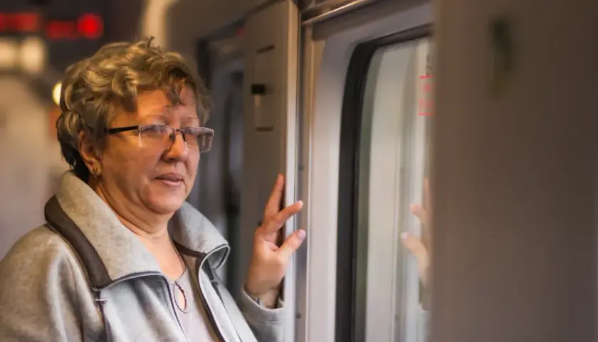 Starsza pani w okularach, podróżująca pociągiem PKP Intercity, cieszy się z 70 lat darmowych przejazdów.