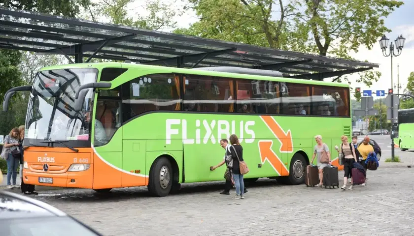 Zieloni Flixbus z pasażerami i bagażami. Studenci podróżują taniej dzięki flixbus zniżka studencka.