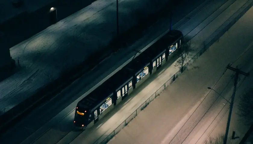 Nocny tramwaj w śnieżnej Warszawie, jak jeden z nielicznych autobusów nocnych, przemierza puste ulice.