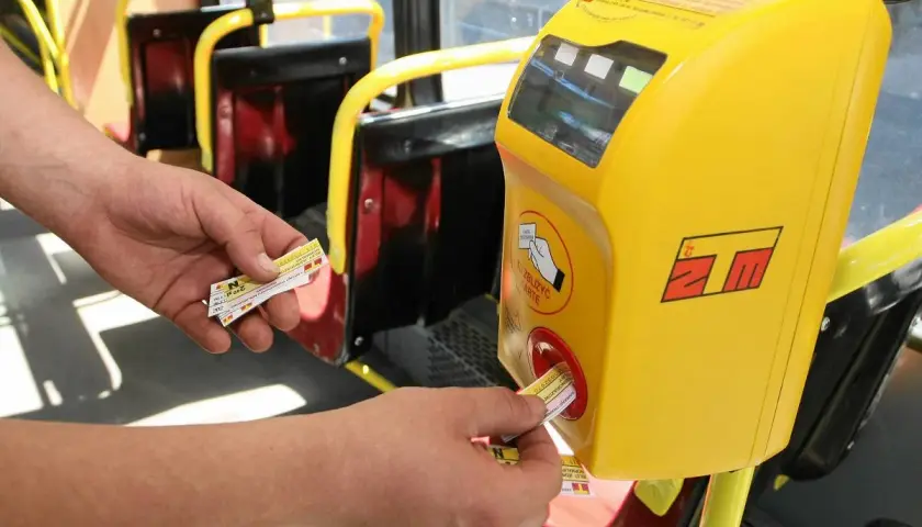 Ręka zbliża bilet do kasownika w autobusie. To prosty sposób, jak dojechać warszawa ztm.