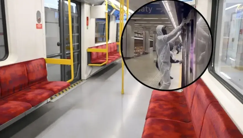 Wnętrze pustego wagonu metra na trasie M2. W okręgu pracownik w kombinezonie dezynfekuje drzwi.