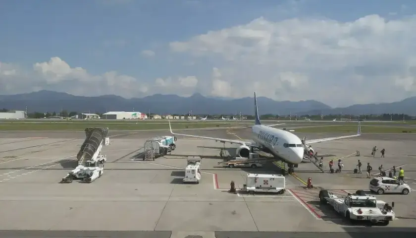 Samolot Ryanair na lotnisku Orio al Serio, pasażerowie wsiadają. W tle góry i chmury.