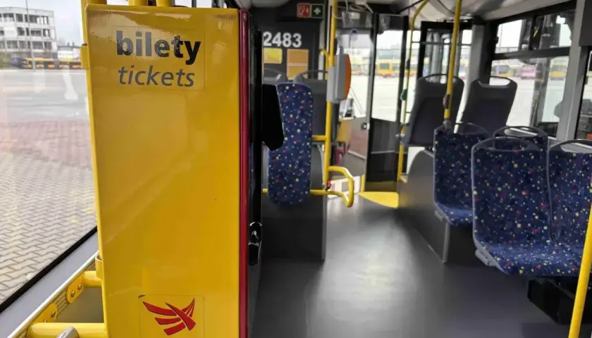 Żółty automat z napisem "bilety" i logo MPK-Łódź wewnątrz autobusu.