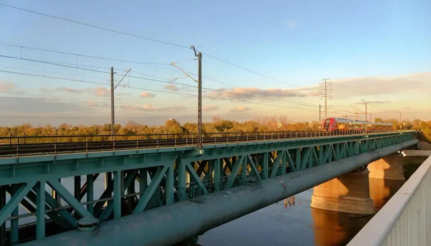Pociąg na moście w Warszawie, idealny do zwiedzania miasta z biletem 3 dniowym.