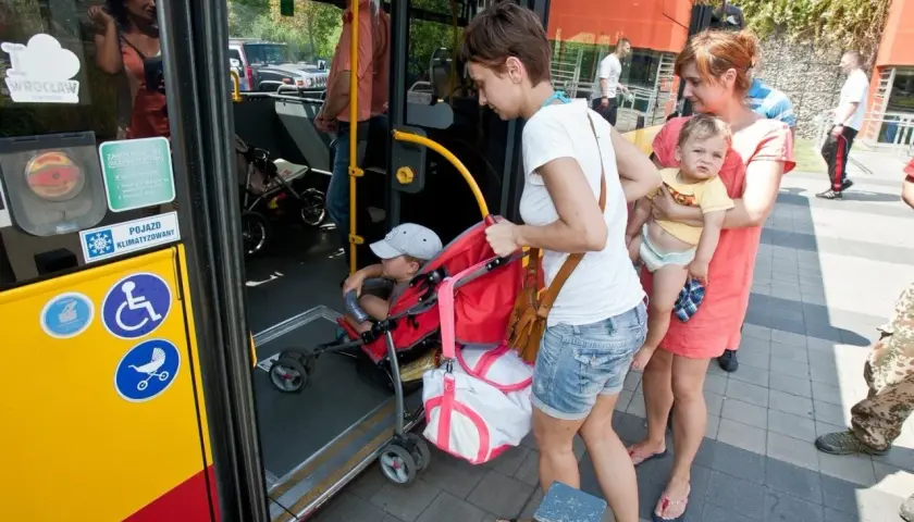 Kobiety z dziećmi wsiadają do autobusu.