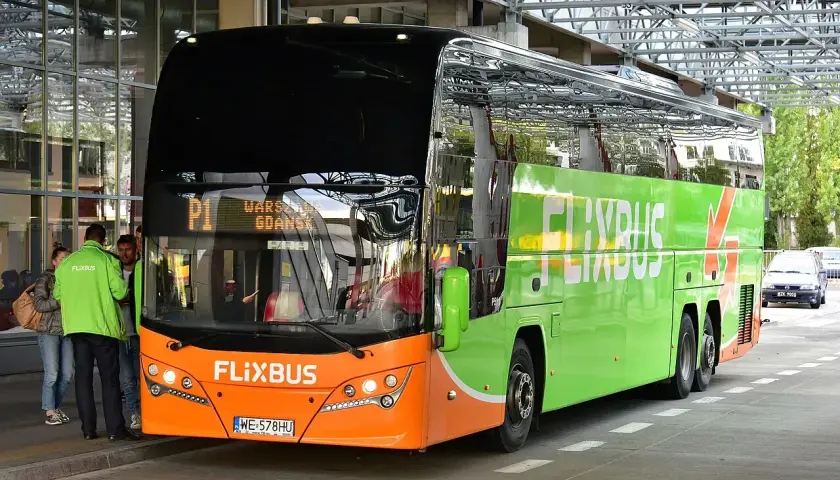 Pomarańczowo-zielony Flixbus z napisem "Warszawa Gdańsk" na wyświetlaczu. Może ktoś właśnie planuje flixbus zwrot biletu?