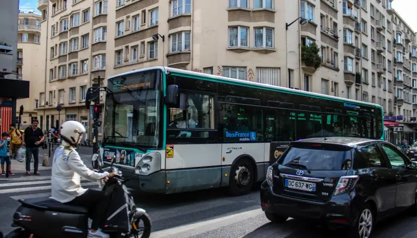 Paryż: autobus miejski i skuter na ulicy, symbolizujące dojazd do centrum z lotniska Charles de Gaulle.