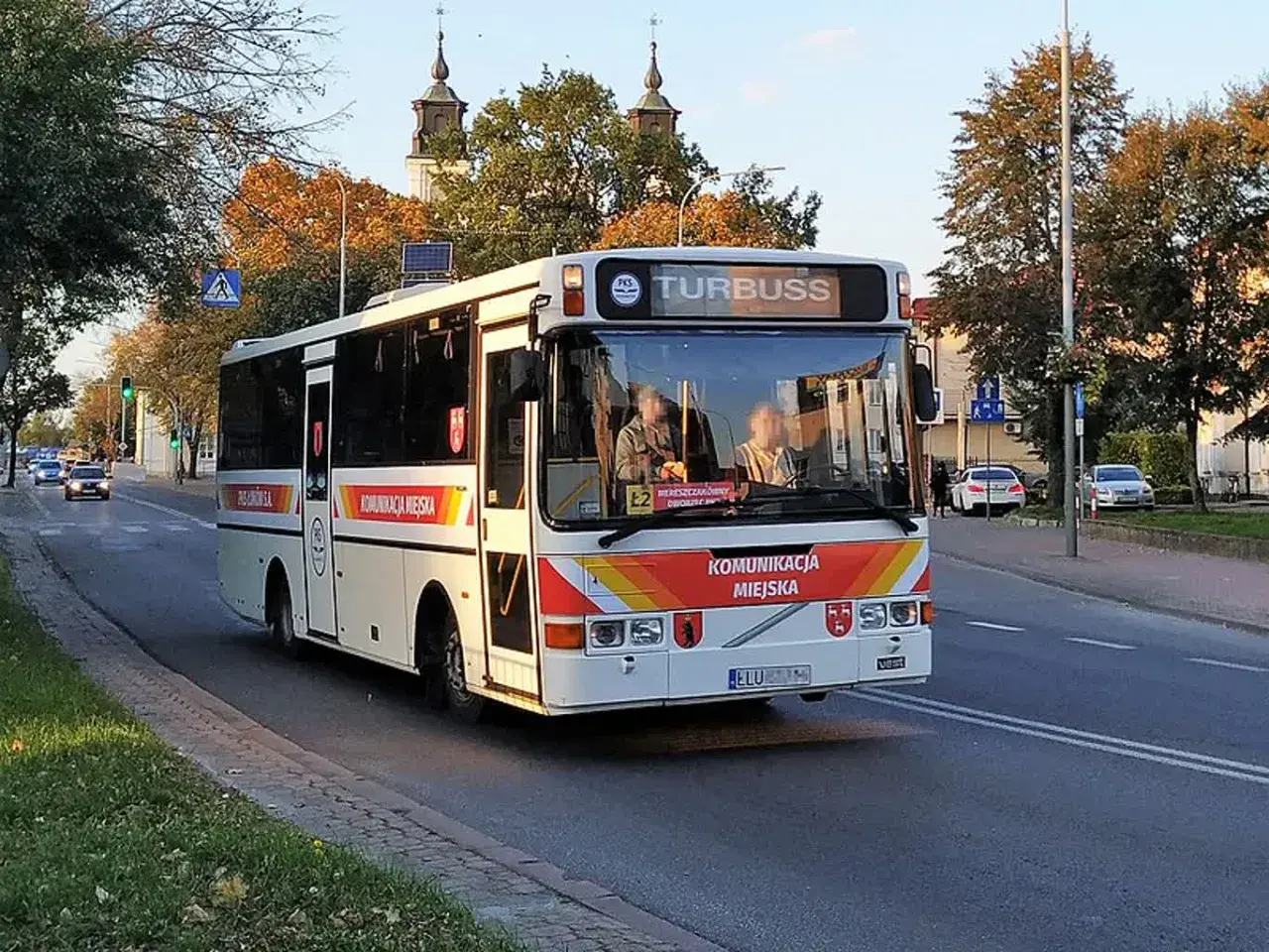 Autobus komunikacji miejskiej "Turbuss" na trasie Łuków-Lublin, z widocznymi herbami miasta i pasażerami.